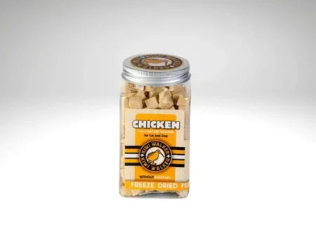 Bocal transparent rempli de petits cubes de poulet lyophilisé, avec une étiquette jaune “Chicken” et un couvercle en métal.