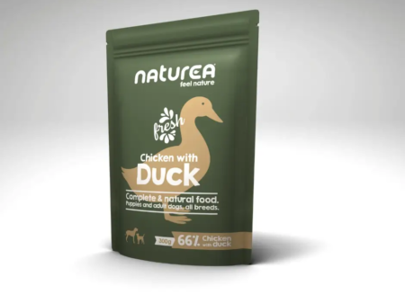 Sachet de pâtée Naturea Poulet au Canard pour chiens, posé sur un fond gris clair.