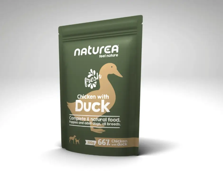 Sachet de pâtée Naturea Poulet au Canard pour chiens, posé sur un fond gris clair.
