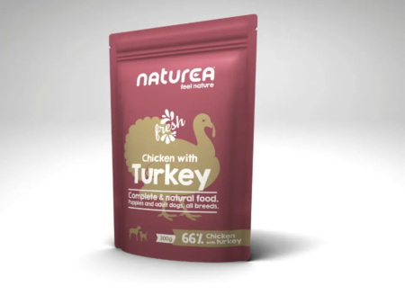 Sachet de pâtée Naturea Poulet Dinde pour chiens, posé sur un fond gris clair.