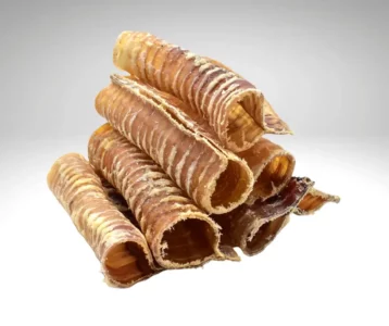 Rouleaux de trachée de bœuf de 30 cm empilés sur fond gris.